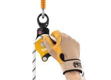 Load image into Gallery viewer, gloved hand placing rope through Petzl Spin L1 pulley with swivel Width=&quot;1200&quot; Height=&quot;861&quot;
