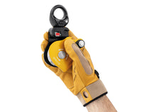 Load image into Gallery viewer, gloved hand holding Petzl Spin L1D pulley with one-way rotation and swivel with open gate Width=&quot;1200&quot; Height=&quot;861&quot;