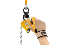 Load image into Gallery viewer, gloved hand placing rope through Petzl Spin L1D pulley with one-way rotation and swivel Width=&quot;1200&quot; Height=&quot;861&quot;